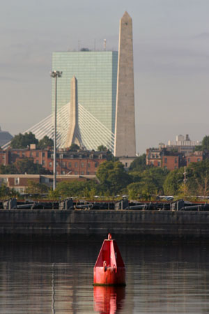 The Boston skyline provides the backdrop for a navigational aid (channel marker) in the Mystic River.