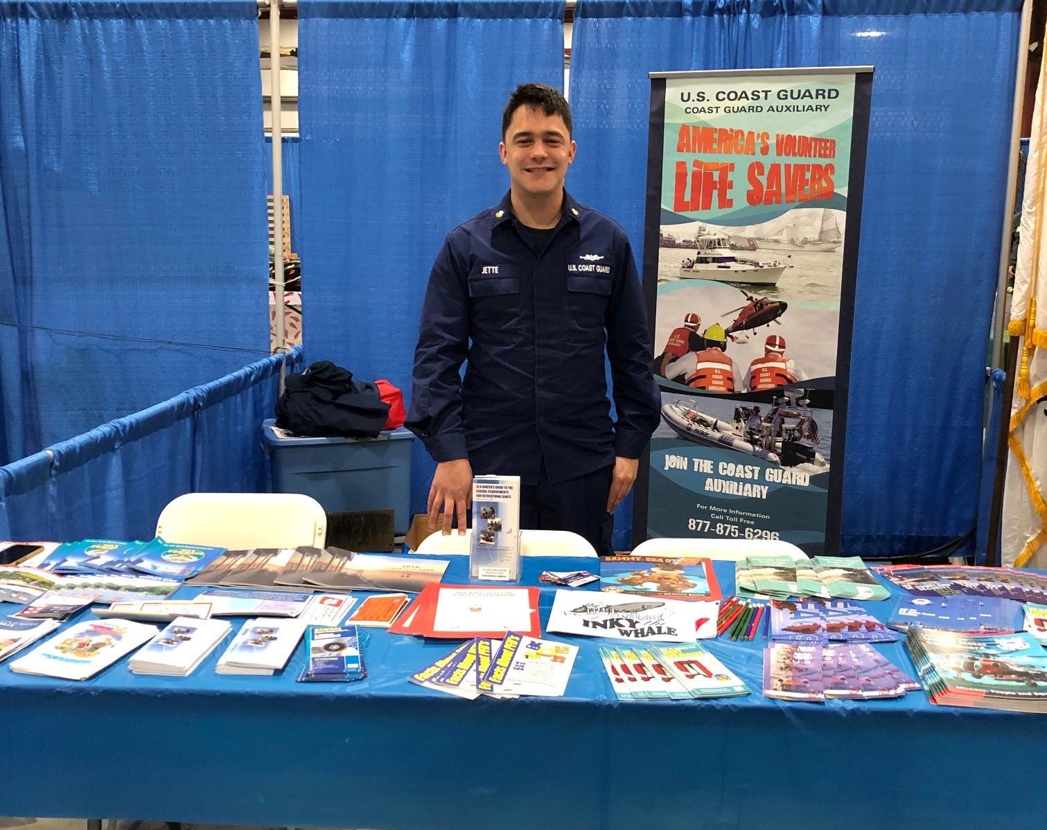 Coast guardsman standing behind boating safety table