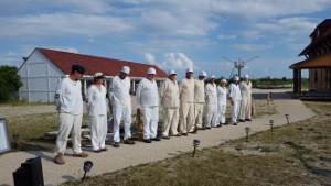 Eleven reenactors in white Life-Saving uniforms, are lined up facing the visitors