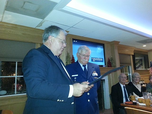 Mike Geletej, standing at left in Blazer uniform, reads the Spoke Award citation as Bob Adams, in Service Dress Blue, listens on