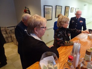 Bob, standing at left, approaches the bar with other attendees