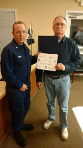 BM2 Carl Crump holds his Membership certificate after being sworn in by BM2 Raxter, in ODU at left
