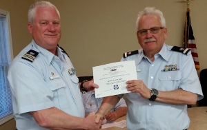Tim Precht, left, shakes hands with Dennis Burgard as they both hold the certificate