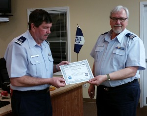 Doc Deiss, standing at left, looks at the certificate while holding it along with Steve Straneva