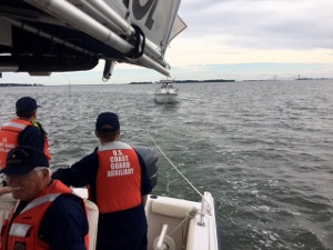 Doug Deiss, at left, and Bruce White keep an eye on the tow as Bob Adams, at the helm, faces forward
