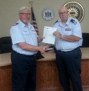 Steve Straneva, at left, shakes hands with Fran Doyle as they both hold the letter of certification