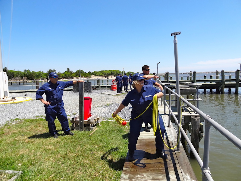 Picture of Auxiliary members throwing a tow line from the dock to a vessel in the water