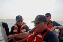 Coast Guard Station Indian River BMC J. Pond (center) oversees training exercises on two CG 47' Motor Lifeboats (MLB) while Auxiliarists Richard Stevenson (Flotilla 12-09 Commander), left, and Auxiliarist Mike McGuire (rear) observe.