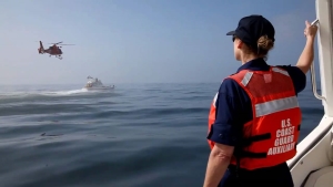 Auxiliary boat crew member observing training exercises
