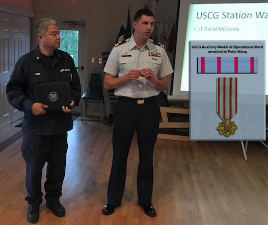 Photo of Auxiliarist Peter Wang receiving the Medal of Operational Merit from LT David McConky.