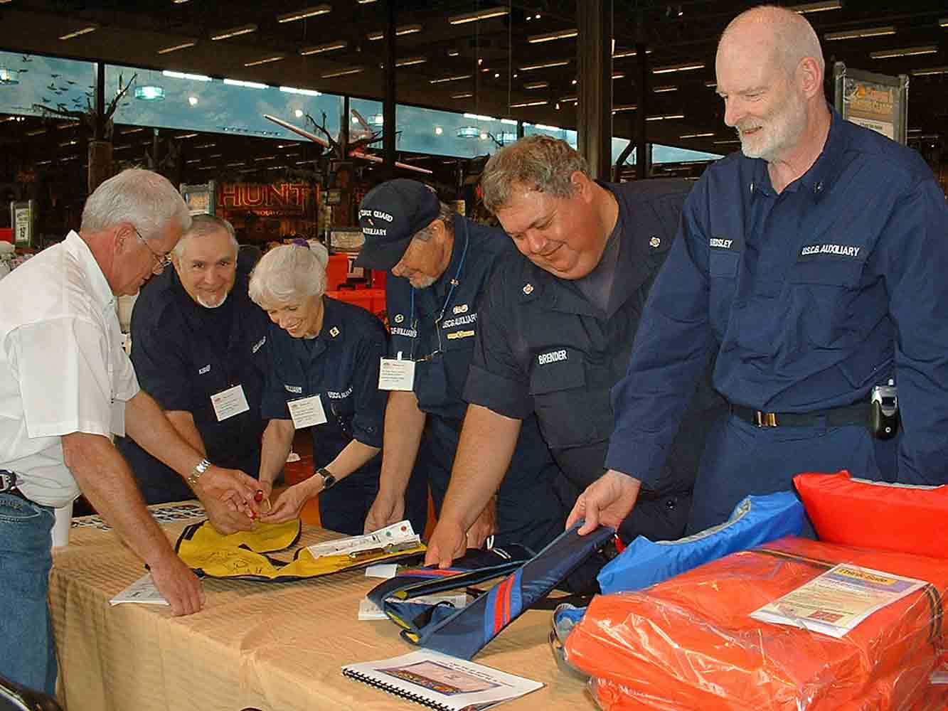 Auxiliarists examining various types of inflatable pfds