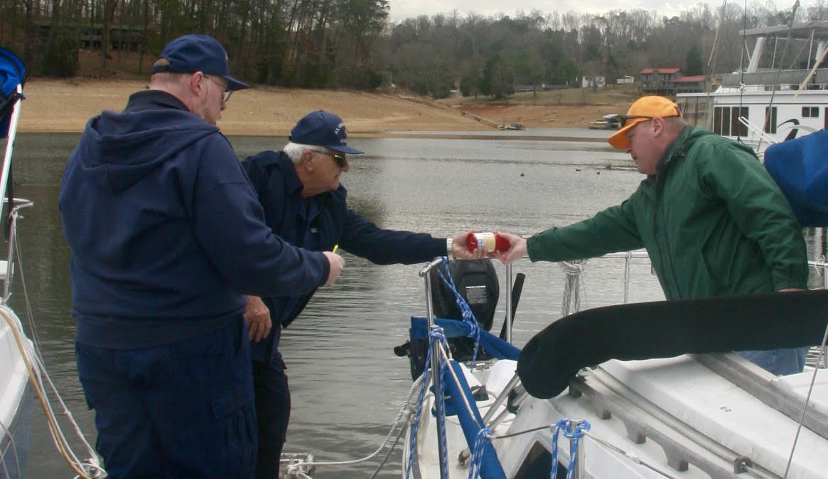 Auxiliary members inspecting a sailboat for safety equipment