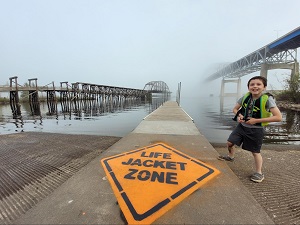 Boy wearing life jacket next to stencil