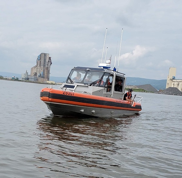 CG boat maneuvers to take AUX boat in tow
