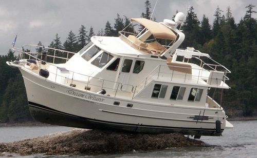 Cabin cruiser sits on the rocks at low tide