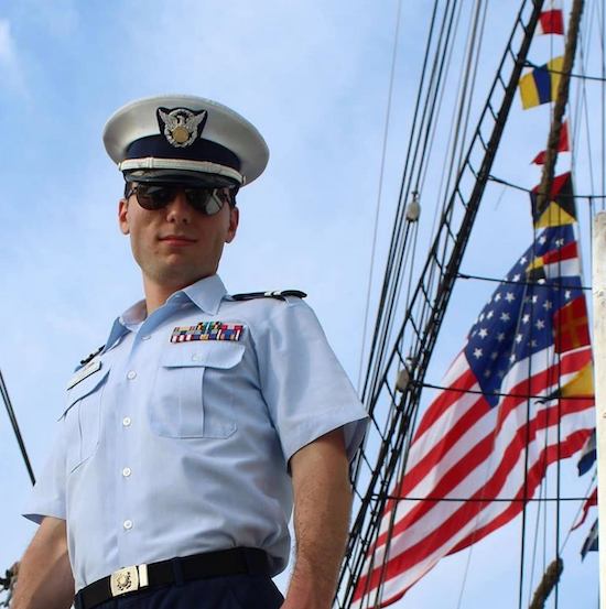 AUX Michael Barth in uniform and sunglasses with U.S. ensign in background