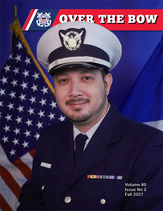 Cover of Over the Bow magazine showing a photo of Auxiliarist Alex Rico wearing a white and blue combo cover and a blue bravo uniform; flags are seen behind him