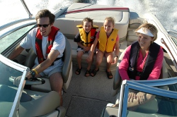 Family on a power boat wearing PFDs