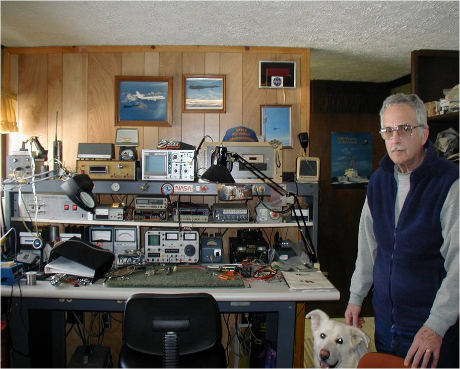 A man and a white dog in front of an elaborate radio station 