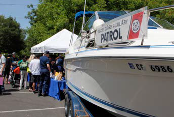 Picture of people at a booth near an Auxiliary patrol boat