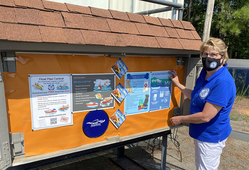 Member in a blue polo shirt poses in front of an outside display case