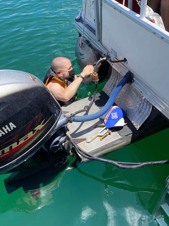 Auxiliarist in the water repairing a boat