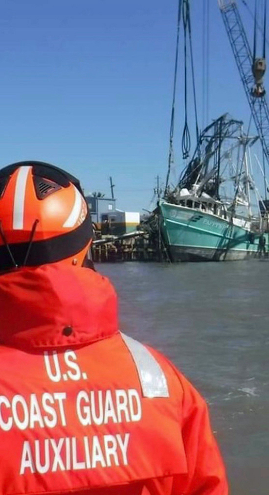 An auxiliarist seen from behind with a vessel in the background