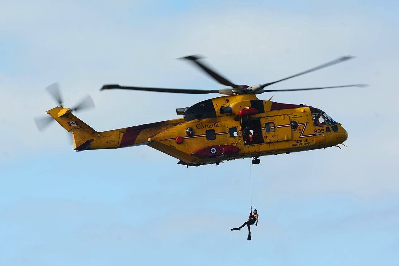 person dangling from helicopter